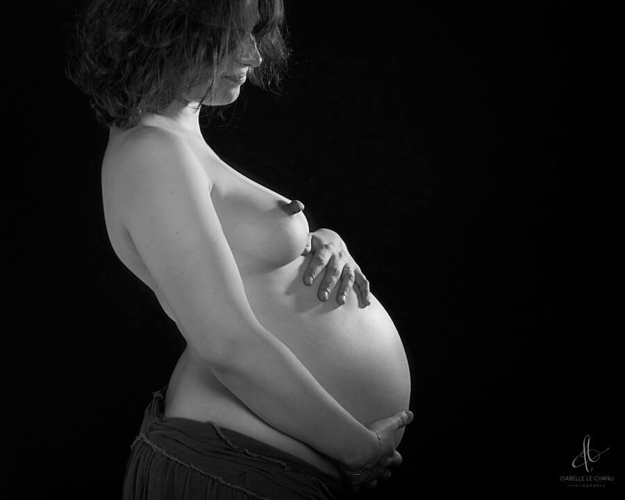 Photographie d'une femme enceinte prise en studio Photo de grossesse en noir et blanc prise en studio